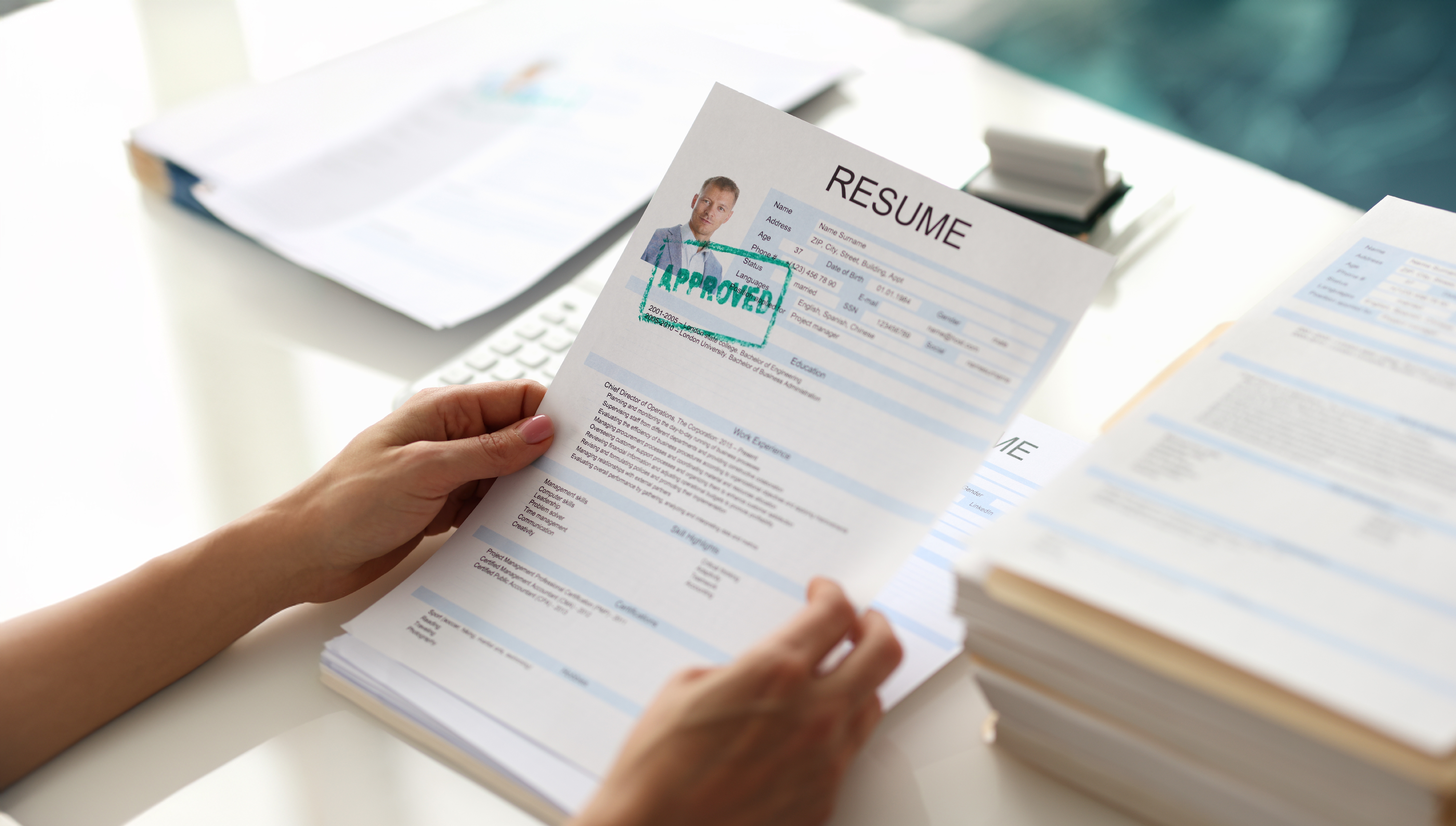 Hands holding a resume for a marketing and sales job.